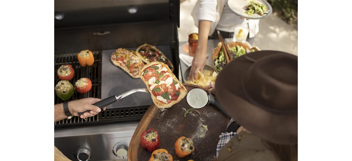 Person removing food from Weber Genesis S-435 Liquid Propane Gas Grill