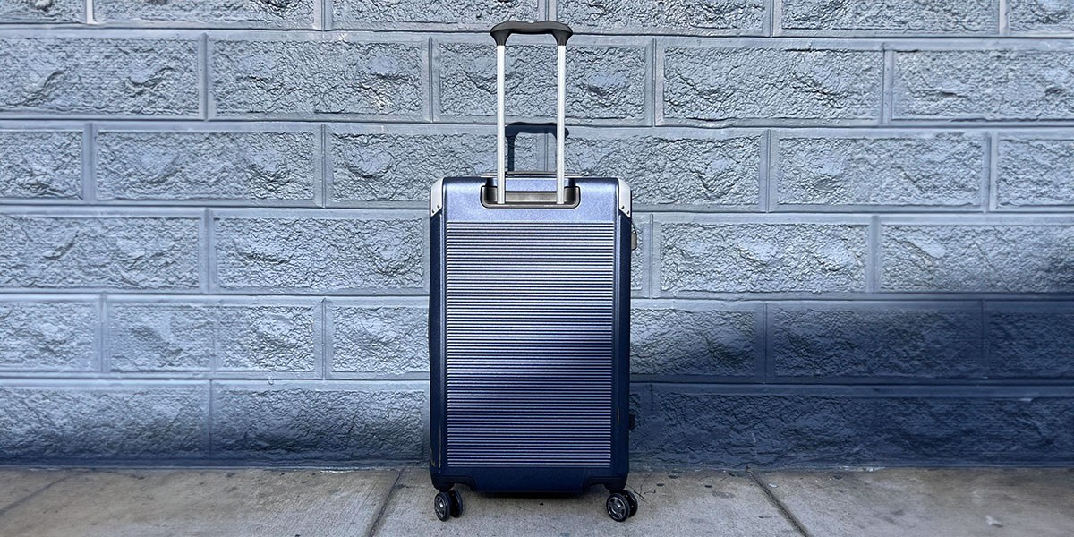 Travelpro Platinum Elite Large Check-In Hardside Spinner in front of wall