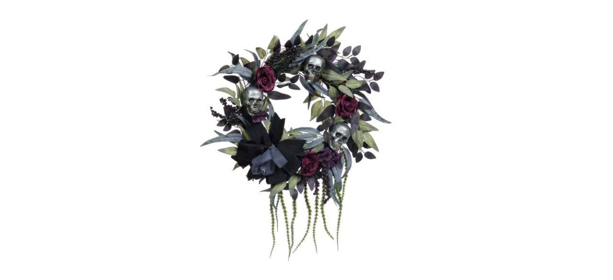a wreath with silver skulls and purple roses on it