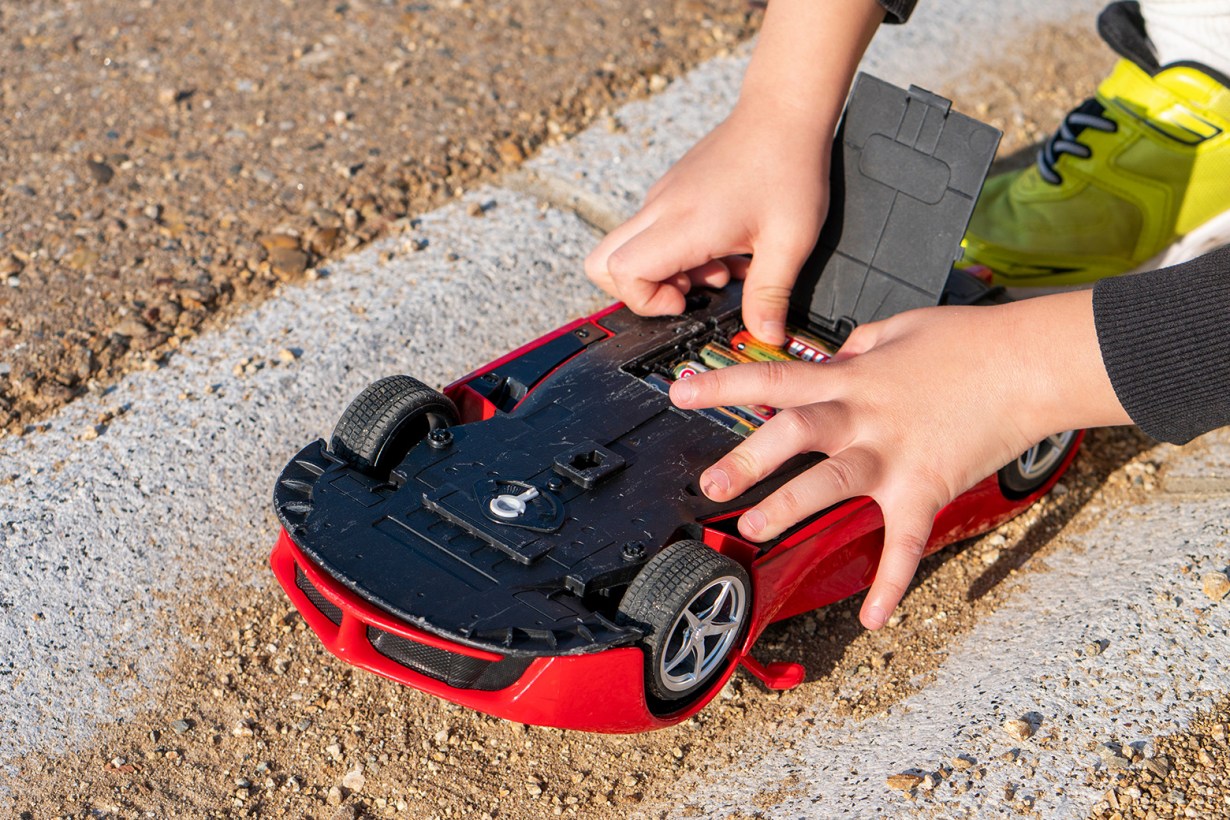 a child using batteries for toy car